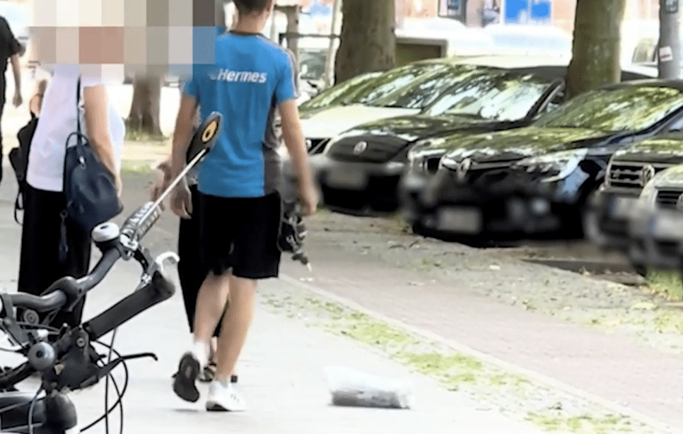 Hermes Skandal Bote tritt Päckchen durch die Stadt
